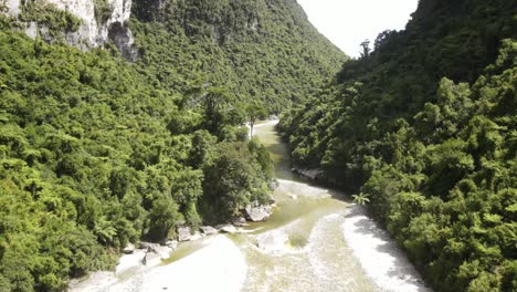Fox-River-in-rocky-canyon,-serene-scene-of-native-rainforest-in-New-Zealand---aerial-drone