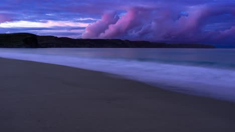 Time-lapse-of-the-sunsetting-over-a-sandy-beach-as-the-tide-comes-in