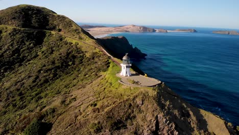Cape-Reinga-Lighthouse-aerial-orbit-reveal-of-beautiful-coastal-scenery-and-Pacific-Ocean