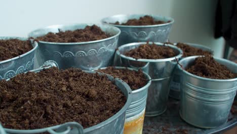 The-pots-are-being-filled-with-soil,-as-the-earth-is-poured-into-them