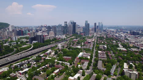 Aerial-view-over-the-Little-Burgundy-neighbourhood,-toward-the-Montreal-skyline,-in-sunny-Quebec,-Canada