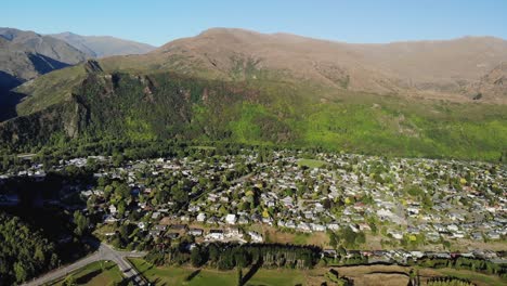 Aerial-wide-shot-of-small,-mountains-surrounded-town