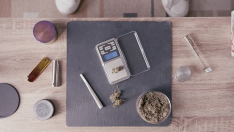 Mann-Wiegt-Medizinisches-Cannabis-Auf-Einer-Waage-Auf-Dem-Tisch