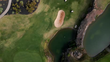 Top-Down-View-of-Green-Golf-Course-with-Large-Pond-in-Center,-Tenerife-Spain