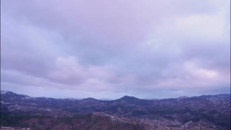Sunrise-in-the-mountain-above-city-in-windy-winter,-time-lapse