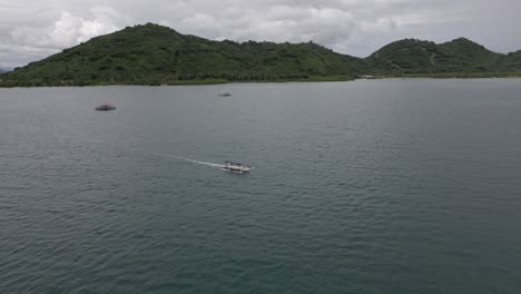 Ascending-aerial-view-of-tour-boat-motoring-in-sea-near-Lombok,-IDN