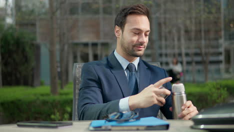 Businessman-Drinking-Coffee-while-Sitting-in-a-Park