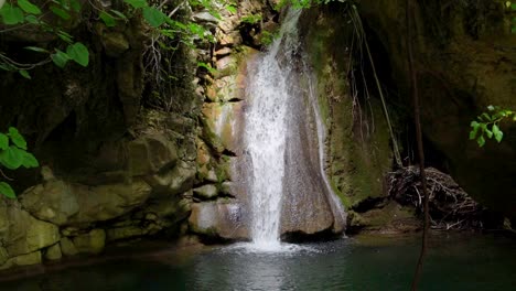 Zeitlupe-Des-Kefalogourna-Wasserfalls,-Umgeben-Von-Grüner-Vegetation-Und-Moosigen-Felsen,-Sonnenlicht-Scheint,-Insel-Thassos,-Griechenland