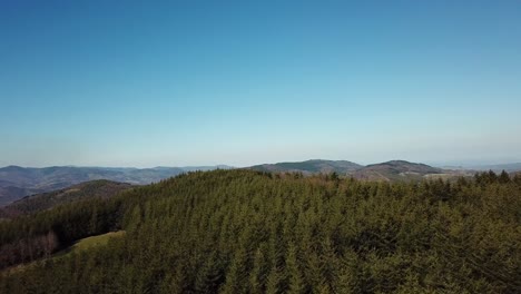 Rising-Drone-Shot-Of-A-Forest-With-Hills-To-The-Horizon-In-Ardèche,-France