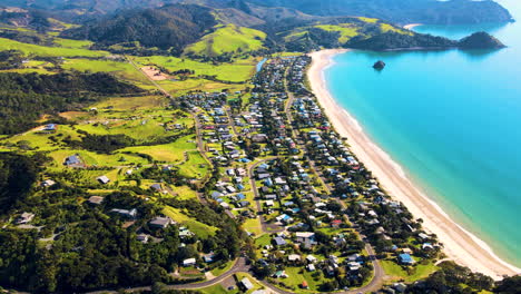 Picturesque-New-Zealand-coastline-with-holiday-houses-and-white-sandy-beach