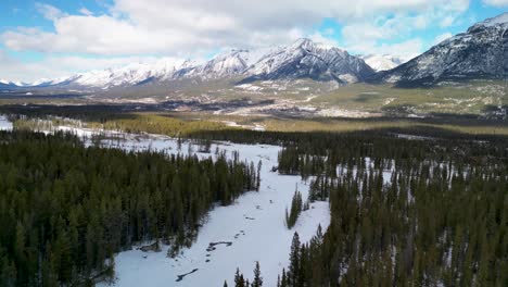 Aerial-descent-of-Canmore-and-Bow-River-Valley,-Alberta,-Canada