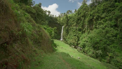 Walking-towards-La-Muralla-waterfall-in-hidden-green-valley,-slow-motion