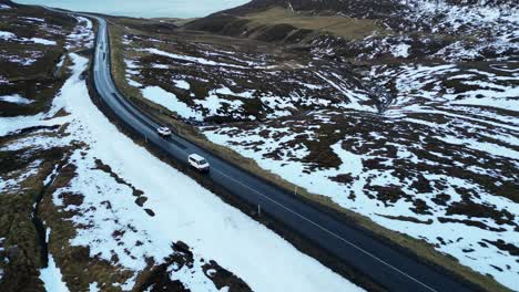 Cars-Drive-on-Road-through-Impressive-Landscape,-Iceland-Winter-Aerial