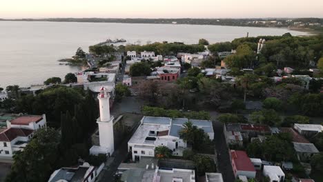 drone-rotate-around-lighthouse-in-colonia-del-sacramento-Uruguay-town-during-warm-golden-hours-sunset