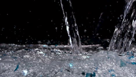 Agua-Reluciente-Y-Brillante-Que-Se-Vierte-En-Un-Fondo-Negro-Con-Brillo-Azul-Y-Cristales