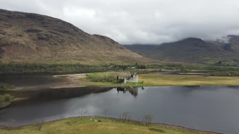 Aerial-view-of-Kilchum-Castle,-an-abandoned-Scottish-fortress-in-a-misty-lake