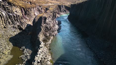 Luftdrohne-Vorwärts-Bewegende-Aufnahme-über-Den-Fluss,-Der-Durch-Die-Studlagil-Schlucht-In-Island-Fließt