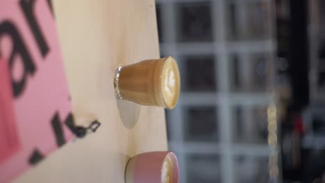 Vertikale-Glastasse-Mit-Wunderschöner-Latte-Art-Blume-In-Goldenem-Karamellkaffee