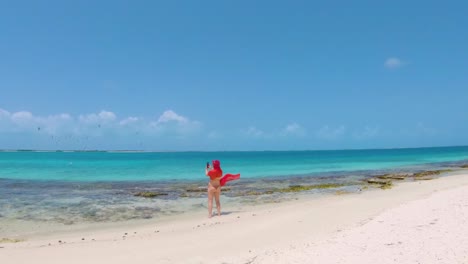 Island-Getaway:-caucasian-woman-red-bikini-take-photo-birds-fly-on-Tropical-paradise-beach