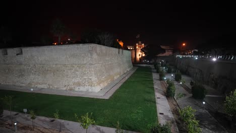 Stone-wall-fortifications-at-night-in-Valletta-capital-city-of-Malta,-Wide-shot