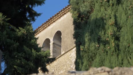 Las-Ventanas-De-Una-Iglesia-Campestre-Francesa-Entre-Cipreses-Con-Cielo-Azul-En-Francia