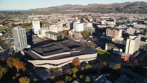 Aerial-view-of-Christchurch-city-centre-with-Cathedral,-square-and-tall-business-buildings,-warm-light