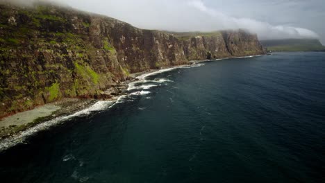 Slow-Lift-Drone-Shot-Of-Rough-Green-Coastline-Cliffs-In-Isle-Of-Skye-Scotland