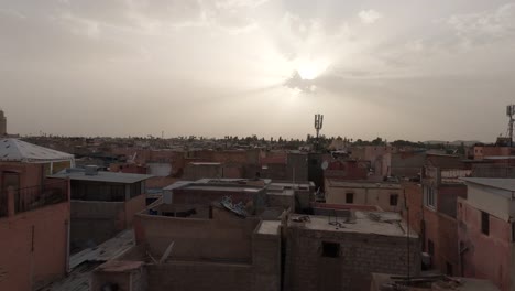 Traditional-Moroccan-sandstone-old-town-homes-rooftops-under-glowing-cloudy-sunset-skyline