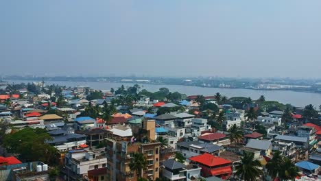 Aerial-view-of-Kochi-city-from-Fort-Kochi-,-A-lake-flowing-through-the-middle-of-Kochi-city-,-Aerial-view-of-crowded-city-houses