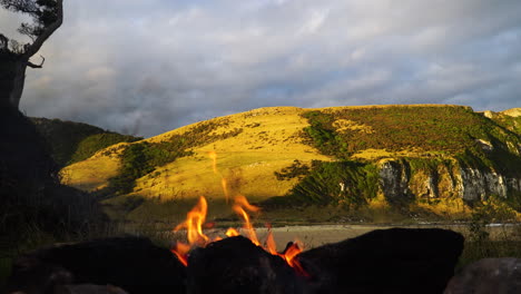 Campfire-while-sunset-in-Purakaunui-beach-in-New-Zealand,-romantic-mood