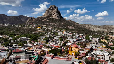 Drone-shot-of-the-Bernal-town-with-the-monolith-in-the-background,-in-sunny-Mexico