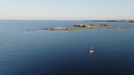 A-cinematic-aerial-view-of-a-boat-in-the-north-of-Menorca,-Spain