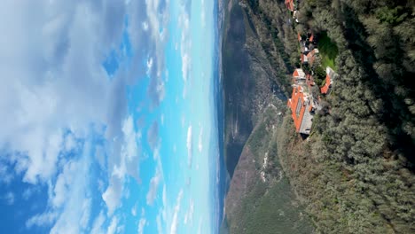 Iconic-Spanish-catholic-monastery-on-top-of-lush-green-mountain,-valley-views