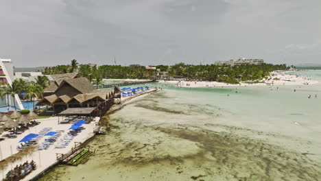 Isla-Mujeres-Mexico-Aerial-v15-low-flyover-Mia-Reef-towards-town-center-capturing-beautiful-Playa-Norte-white-sand-beach,-sandbars-formation-and-resort-villas---Shot-with-Mavic-3-Cine---July-2022