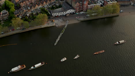 Pan-up-aerial-shot-from-Putney-riverside-rowing-club-to-London-skyline