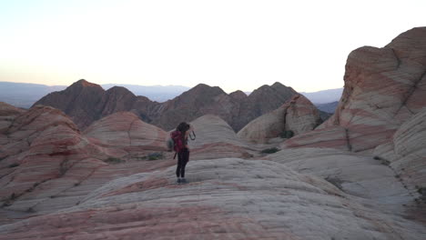 Mujer-Con-Mochila-Tomando-Fotos-De-Formaciones-Rocosas-En-Utah-Usa