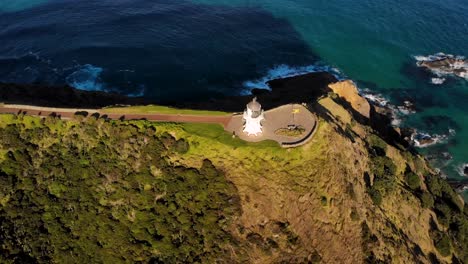 Lighthouse-of-Cape-Reinga-aerial-reveal-endless-Pacific-Ocean-on-horizon
