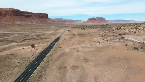 Aerial-view-of-a-a-road-leading-to-Monument-Valley,-Arizona,-USA-in-April
