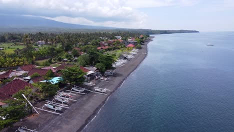 Aerial-drone-view-above-seaside-of-Amed-Village-on-clear-sky,-Bali-Indonesia