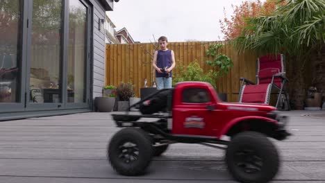 Young-boy-at-home-outdoors-in-the-garden-playing-with-his-RC-Car,-Truck,-4-x-4