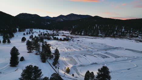 Mitten-Im-Winter,-Colorado,-Sonnenuntergang,-Goldene-Stunde,-Immergrüner-See-Unter-Lichtern,-Hockeyspielen-Auf-Verschiedenen-Eisbahnen,-Filmkreis