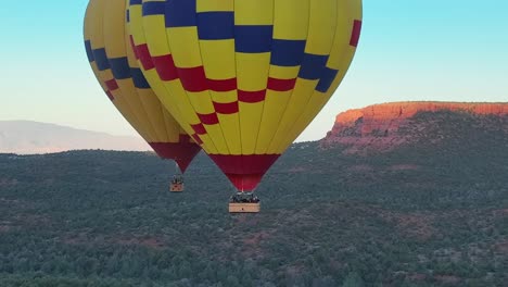 Two-Hot-Air-Balloons-At-Sunrise-In-The-Desert-Of-Arizona,-USA---aerial-drone-shot
