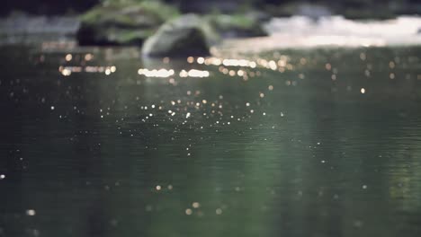 Water-glistens-and-sparkles-as-it-flows-down-creek,-slow-motion