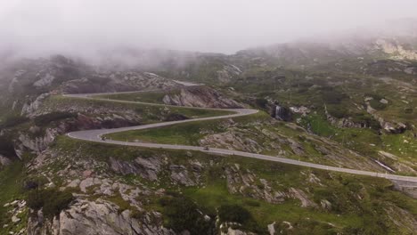 4K-Drohnenaufnahmen-Fangen-Die-Natürliche-Schönheit-Der-Schweizer-Alpen-Ein,-Während-Die-Sonne-Am-Gotthardpass-Durch-Die-Wolken-Untergeht