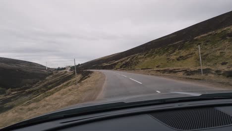 Driving-through-the-scenic-Scottish-Highlands-in-an-SUV,-capturing-the-immersive-experience-from-the-inside-of-the-car-through-the-windshield