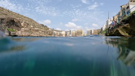 S-close-up-of-a-popular-swimming,-snorkeling,-and-diving-place-and-a-perfect-diving-site,-in-the-water-of-Xlendi-Bay-on-Gozo's-southwest-coast
