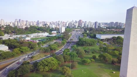 Obelisco-monument-near-Ibirapuera-park-in-downtown-Sao-Paulo,-Brazil--aerial-slow-long-shot