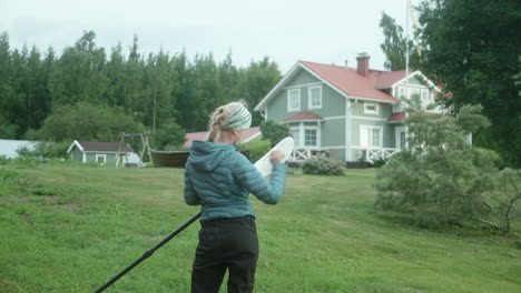 Nordic-Blonde-Girl-Cleaning-Kayak-paddle,-Beautiful-Sunny-Morning-Atmosphere,-Finland,-Kvarken-Archipelago