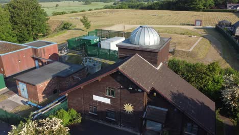 Erstellung-Einer-Luftaufnahme-Des-Pex-Hill-Leighton-Observatoriums-Mit-Silberner-Kuppel-Auf-Dem-Dach-Eines-Ackerlandes-Auf-Einem-Hügel-Bei-Sonnenaufgang