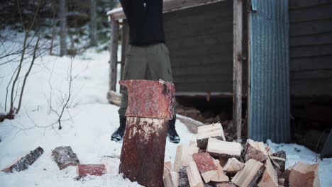 Person-Chopping-Wood-Logs-Outdoor-During-Winter